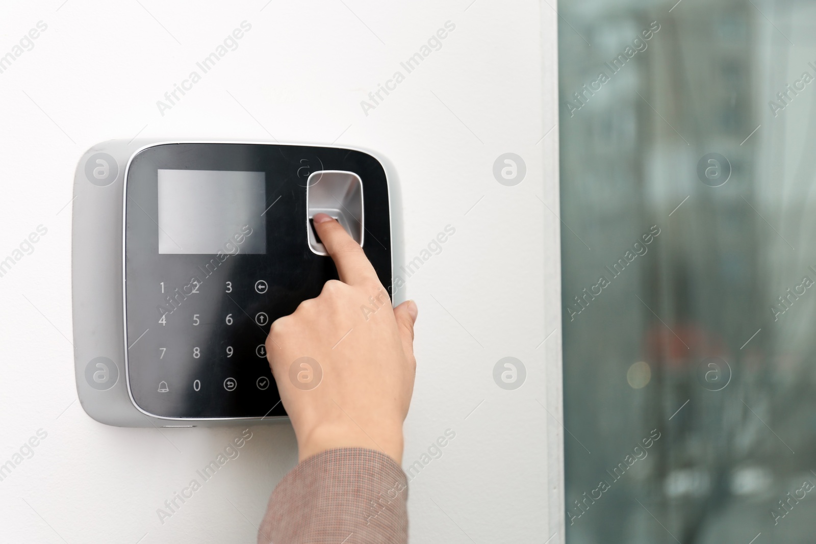 Photo of Woman scanning fingerprint on alarm system indoors, closeup. Space for text
