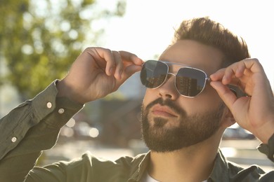 Photo of Handsome man in sunglasses outdoors on sunny day