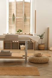 Stylish massage room interior with spa table in salon