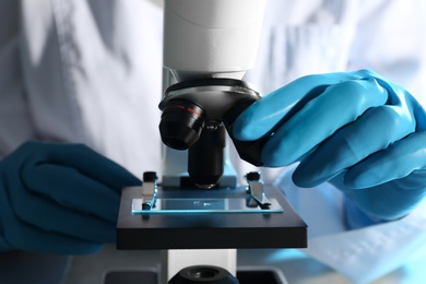 Photo of Scientist working with modern microscope, closeup. Chemical research