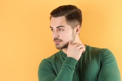 Portrait of young man with beautiful hair on color background