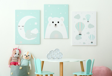 Photo of Adorable wall art, table and chairs with bunny ears in children's room interior