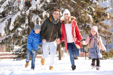 Photo of Happy family running in winter park