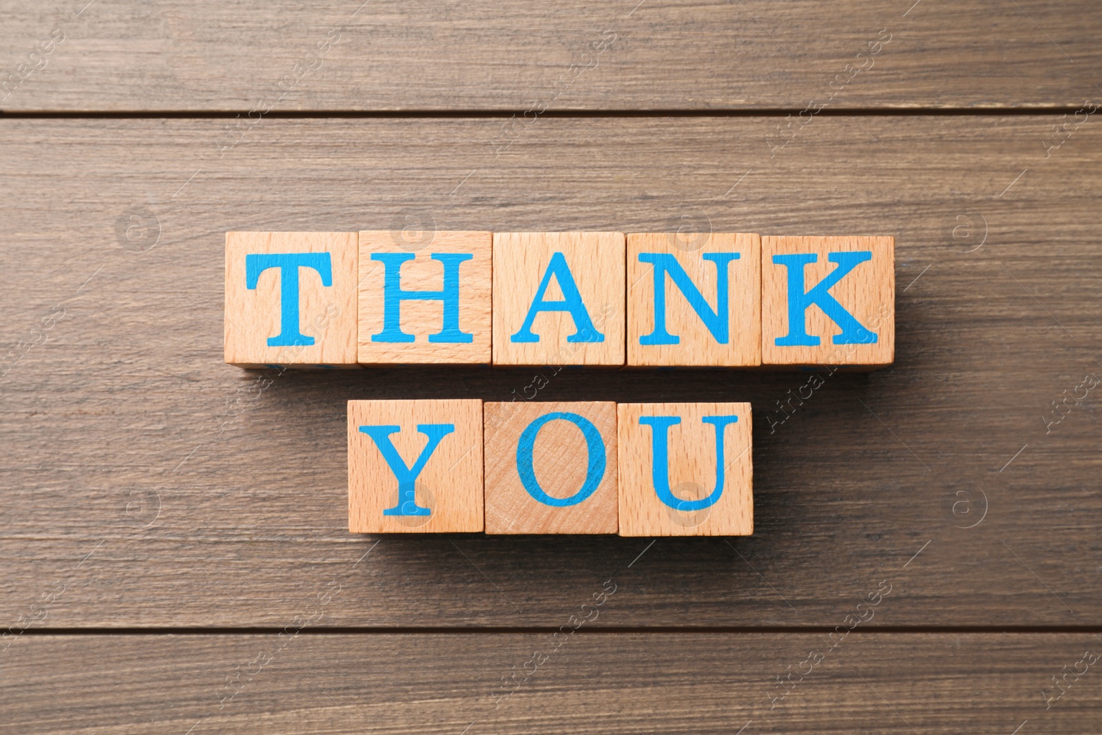 Photo of Phrase Thank You made of cubes with letters on wooden table, flat lay
