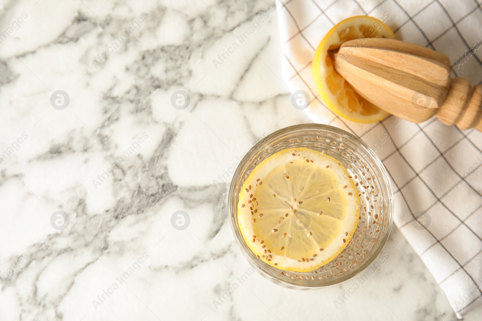 Photo of Flat lay composition with glass of water and chia seeds on marble background, space for text