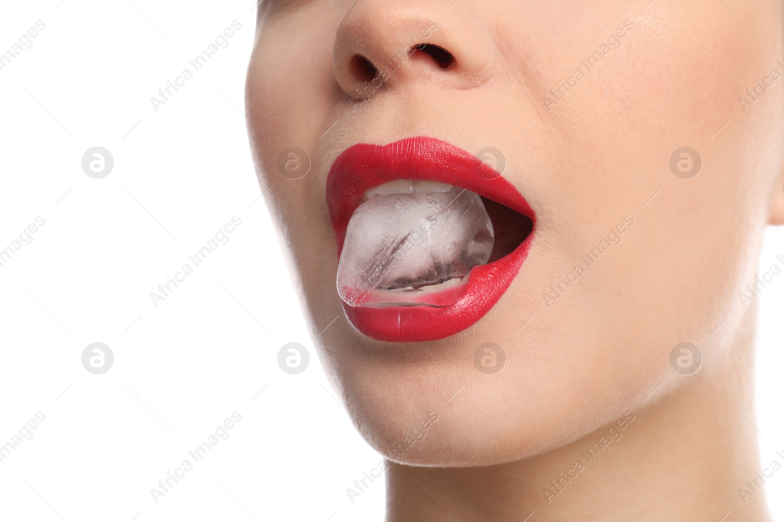 Photo of Young woman holding ice cube in mouth on white background, closeup