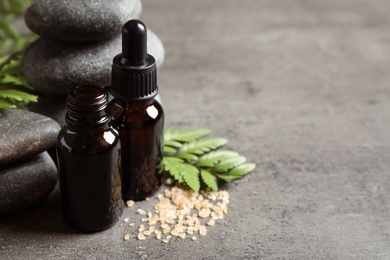 Photo of Spa composition with aroma oil on grey table, space for text