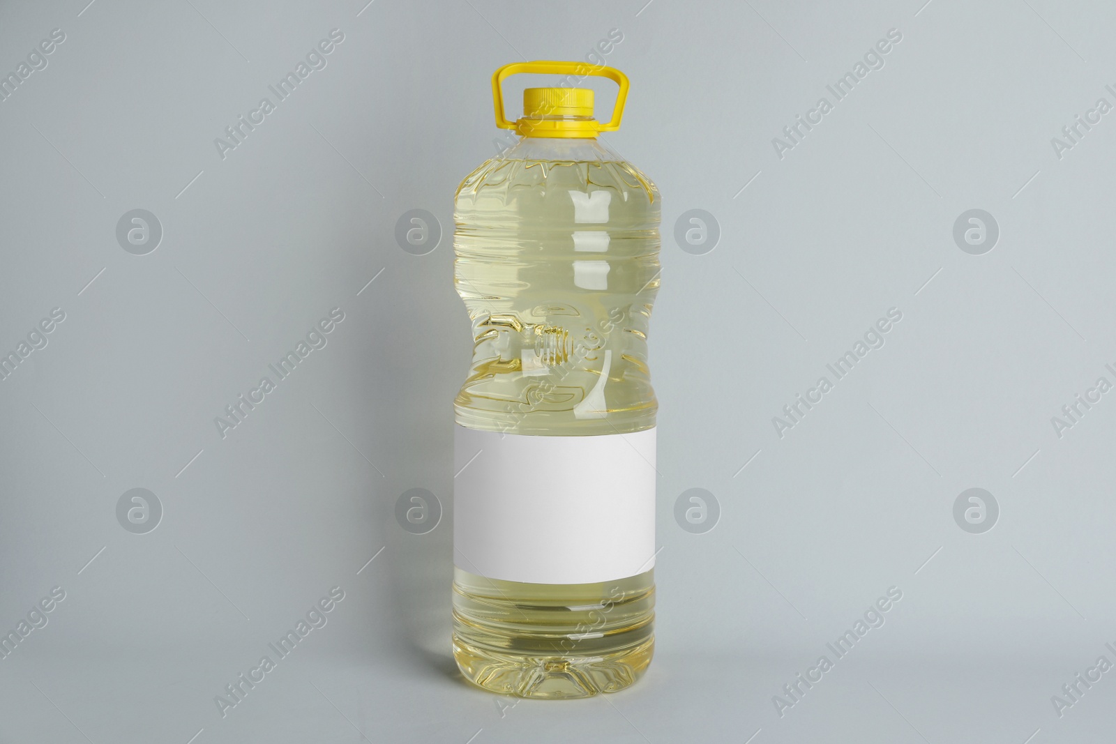 Photo of Bottle of cooking oil on light grey background