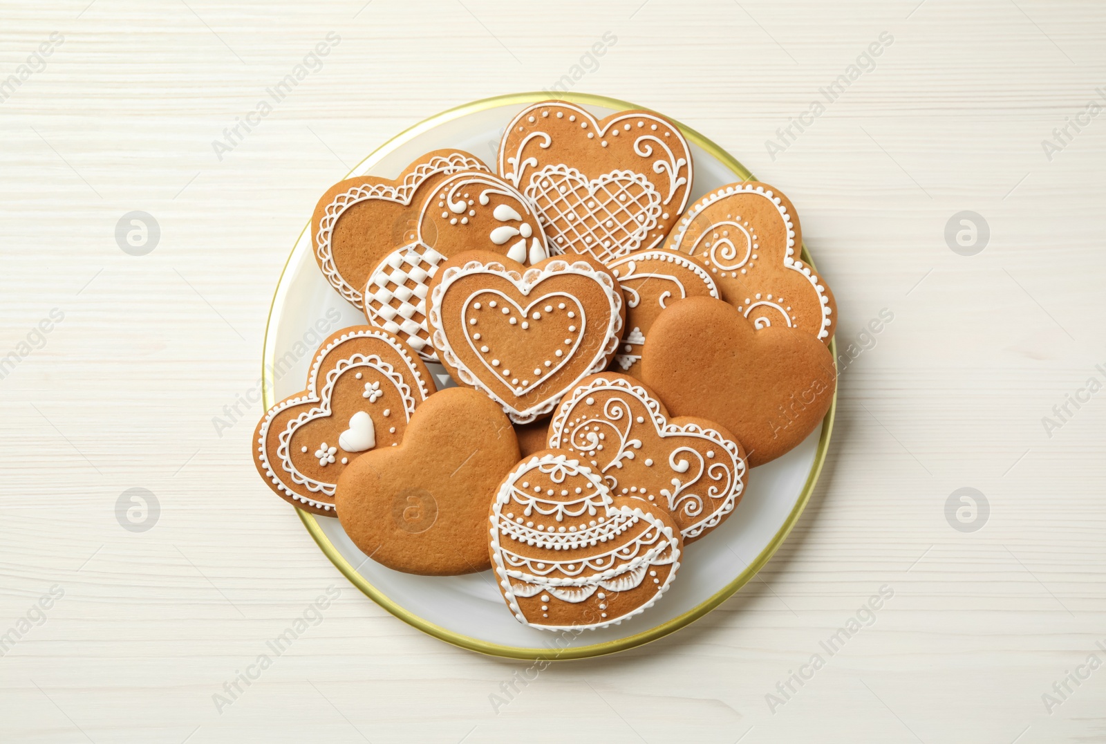 Photo of Tasty heart shaped gingerbread cookies on white wooden table, top view