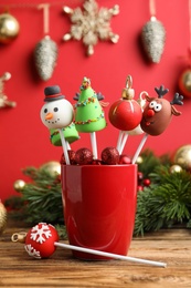 Photo of Delicious Christmas themed cake pops on wooden table