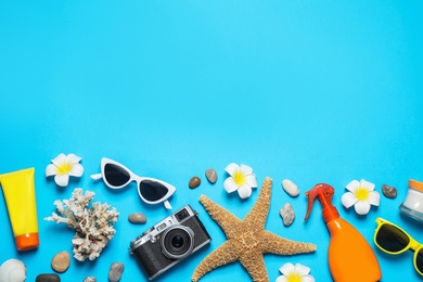 Flat lay composition with stylish beach accessories on light blue background, space for text