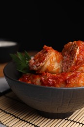 Photo of Delicious stuffed cabbage rolls cooked with tomato sauce on table, closeup. Space for text