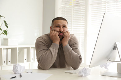 Photo of Lazy overweight office employee procrastinating at workplace