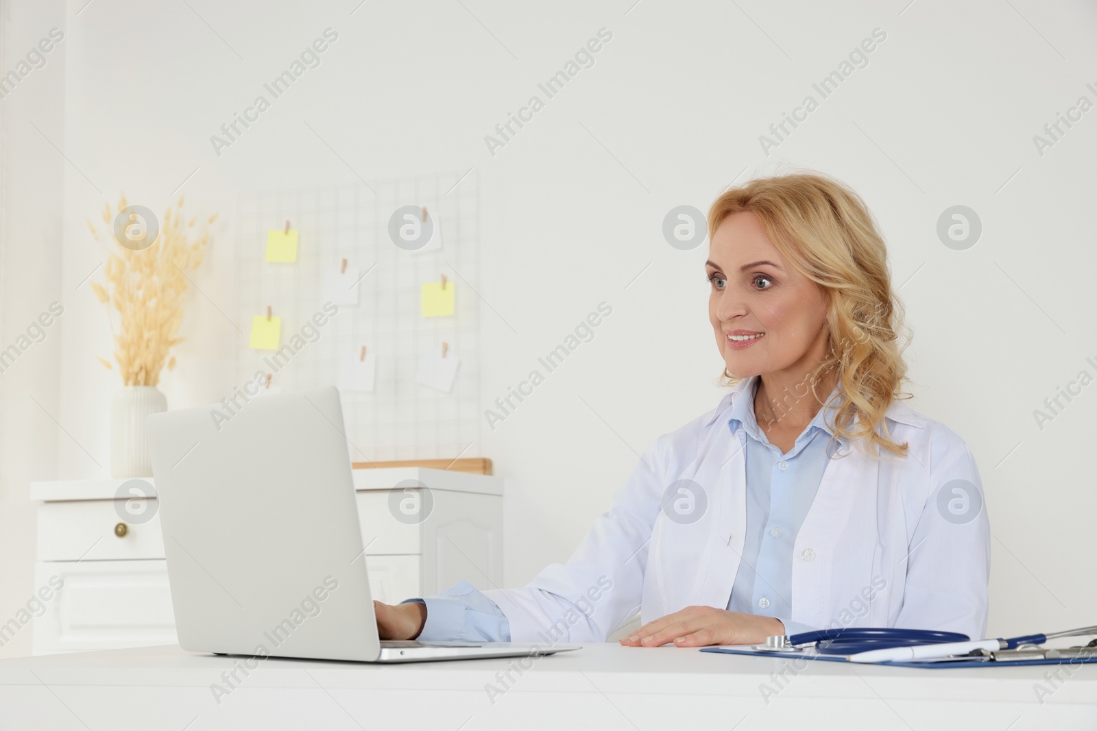 Photo of Doctor with laptop consulting patient in clinic. Online medicine concept