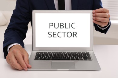 Image of Public Sector. Man with modern laptop at white table, closeup 