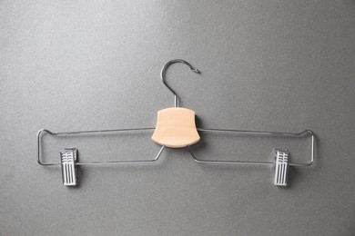 Hanger with clips on grey background, top view