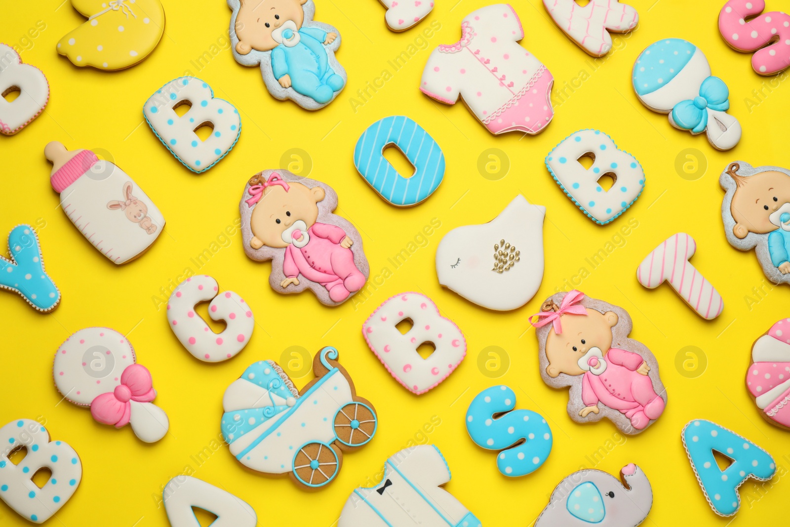 Photo of Set of baby shower cookies on yellow background, flat lay