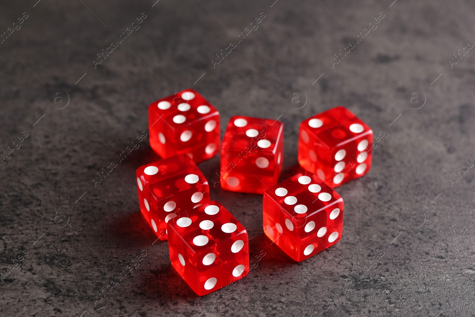 Photo of Many red game dices on grey textured table