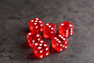 Many red game dices on grey textured table