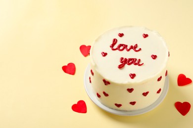 Photo of Bento cake with text Love You and paper hearts on beige table, space for text. St. Valentine's day surprise