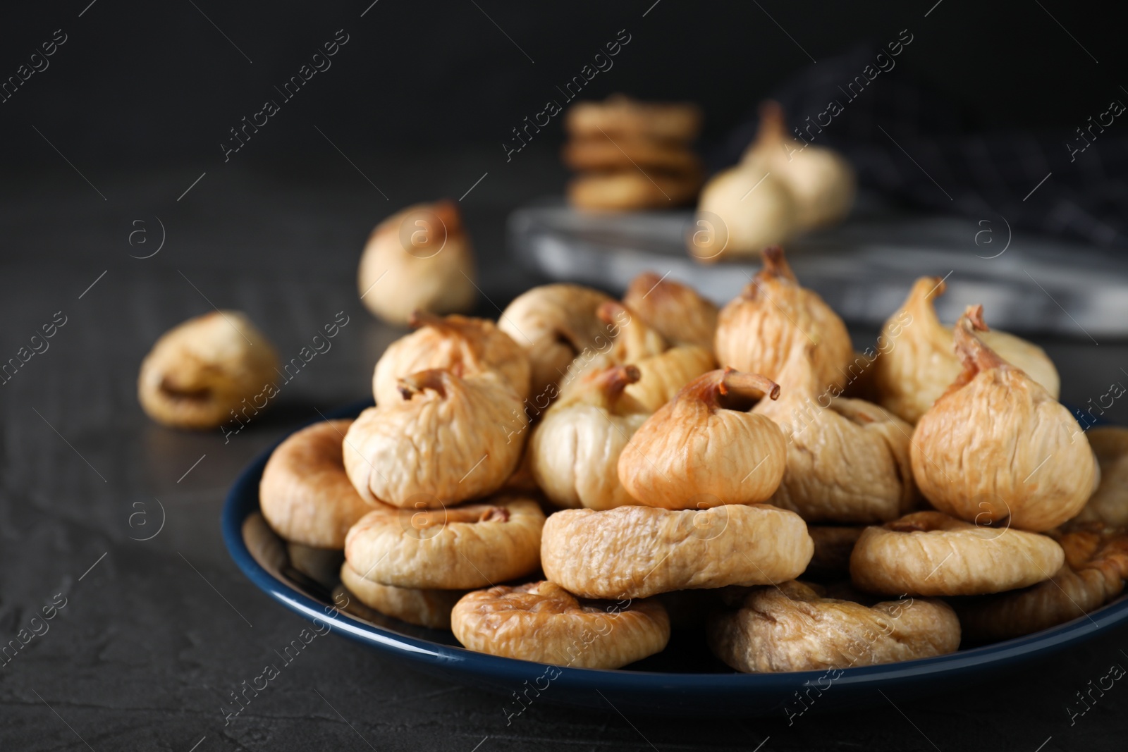 Photo of Tasty dried figs on grey table, closeup