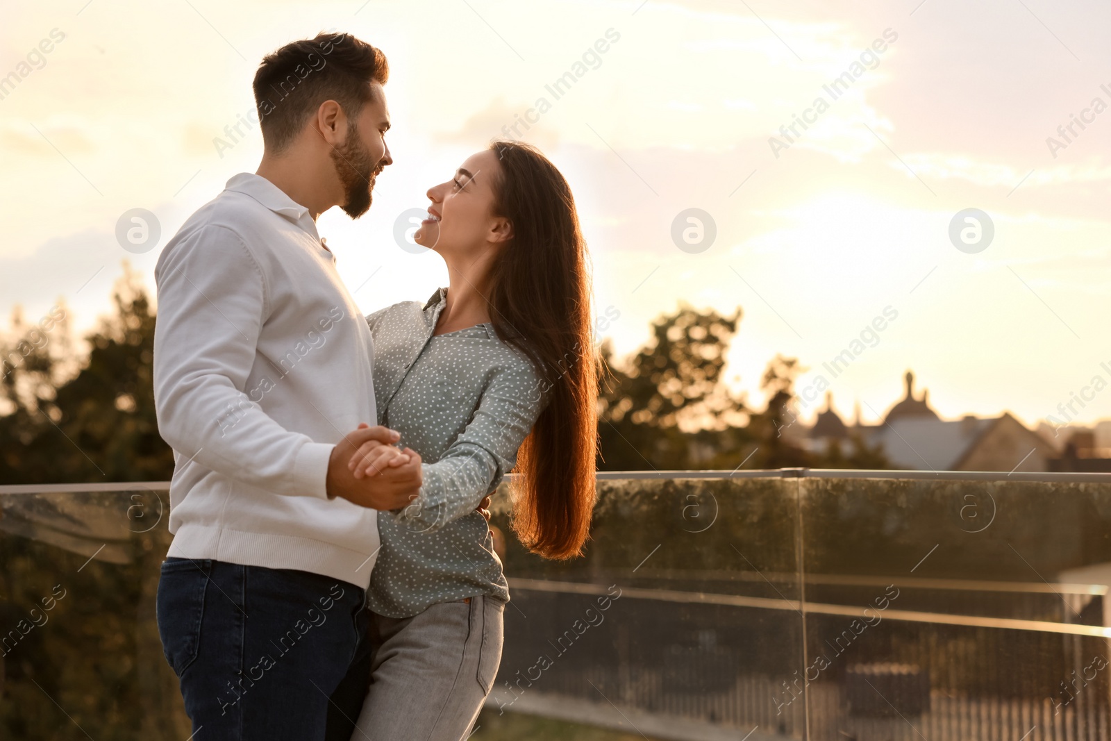 Photo of Lovely couple dancing together outdoors at sunset, space for text