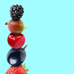 Image of Stack of different fresh tasty berries and cherry on cyan background, space for text