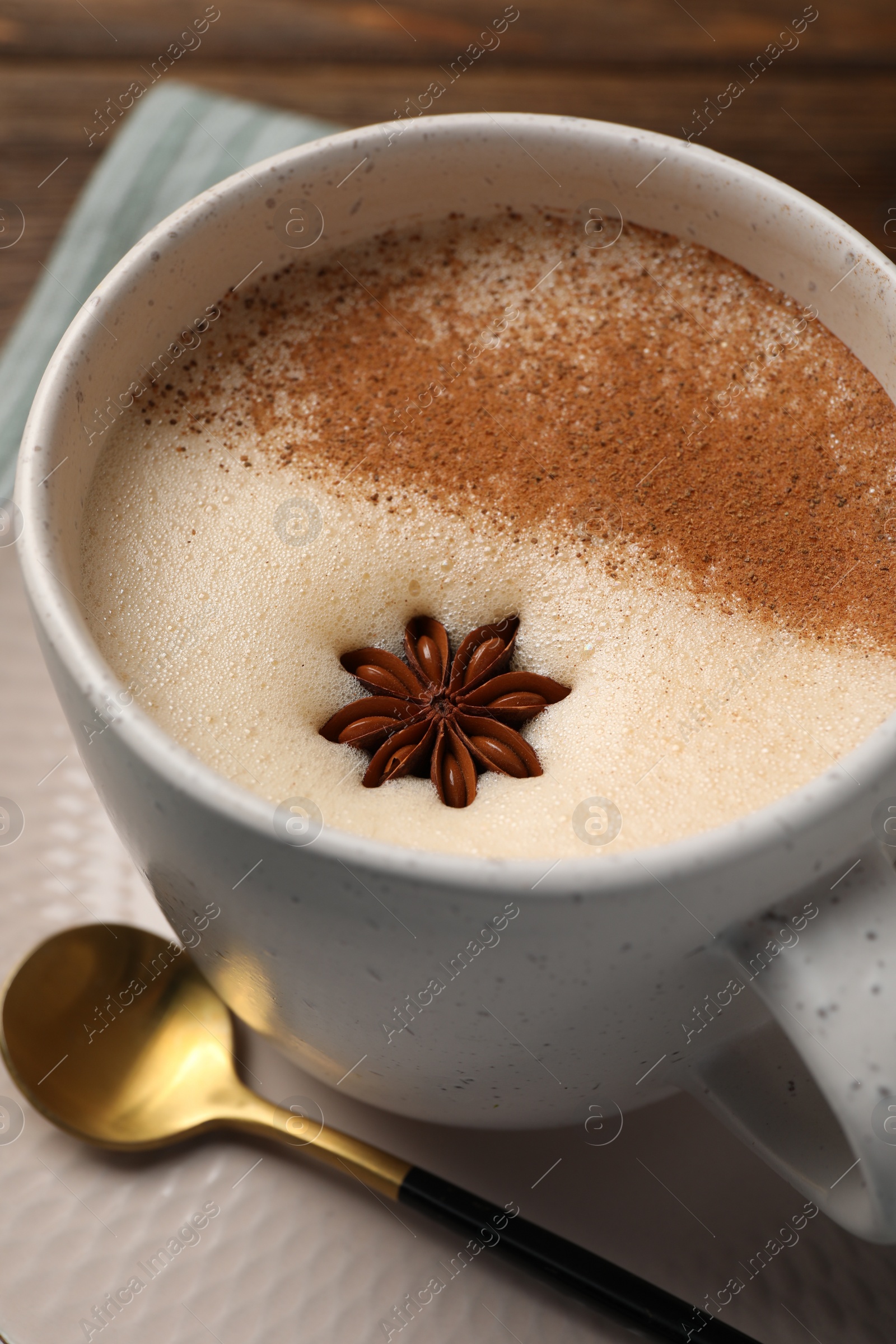 Photo of Cup of delicious eggnog with anise on wooden table