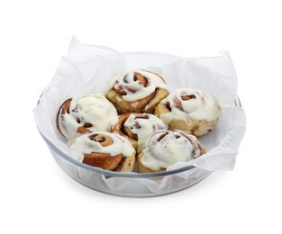 Photo of Tasty cinnamon rolls with cream in baking dish isolated on white