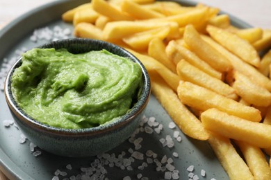 French fries, salt and avocado dip on plate, closeup
