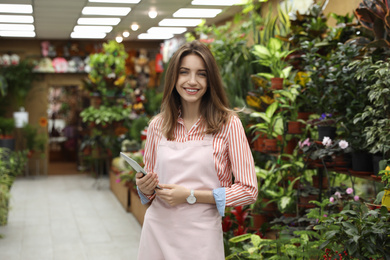 Young business owner with tablet in flower shop