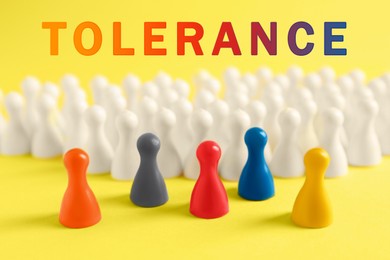 Image of Tolerance, support and cooperation concept. Colorful pawns on yellow background, closeup