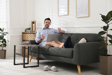 Businessman in underwear pretending to wear formal clothes during video call at home