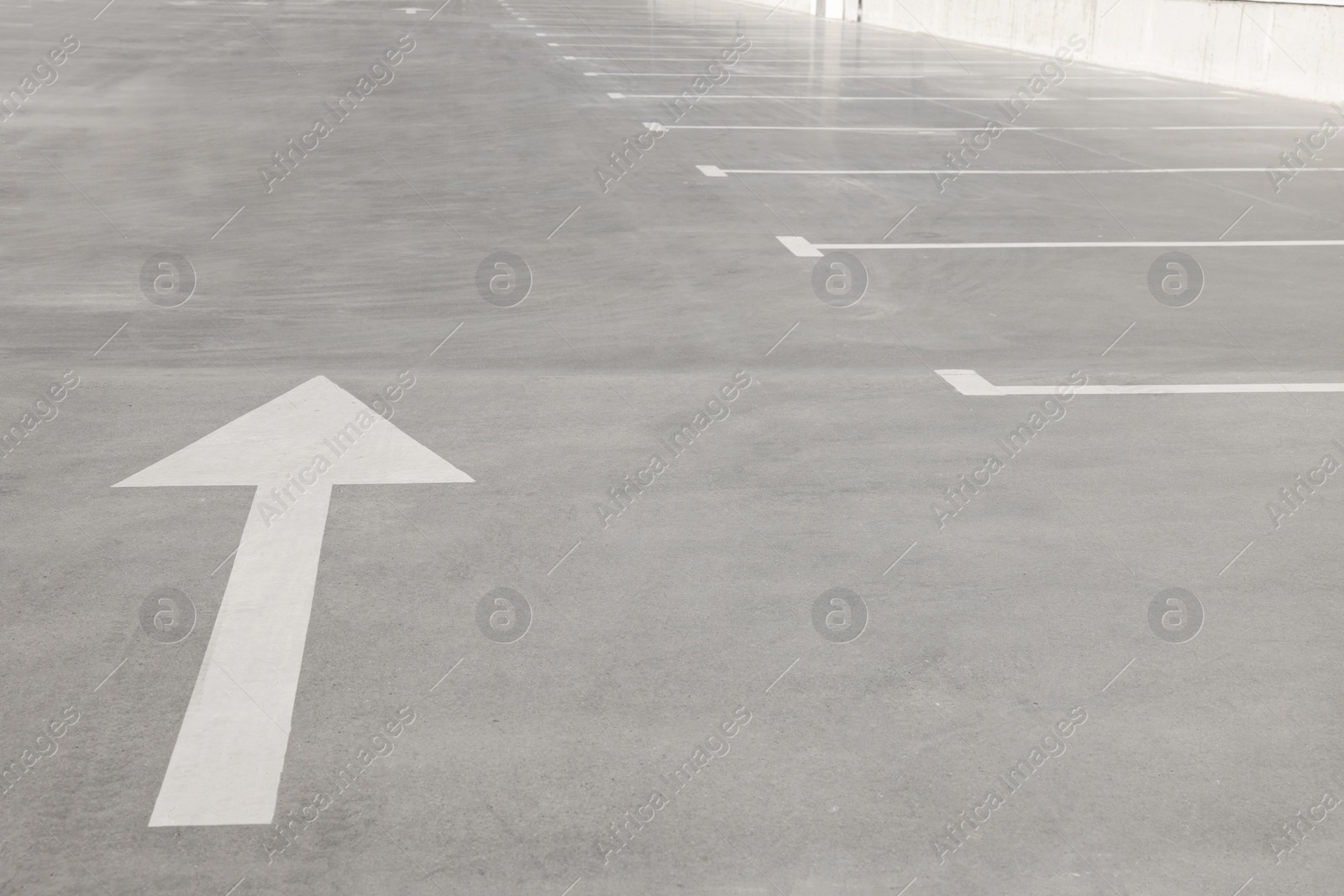 Photo of Outdoor car parking lot with arrow on sunny day