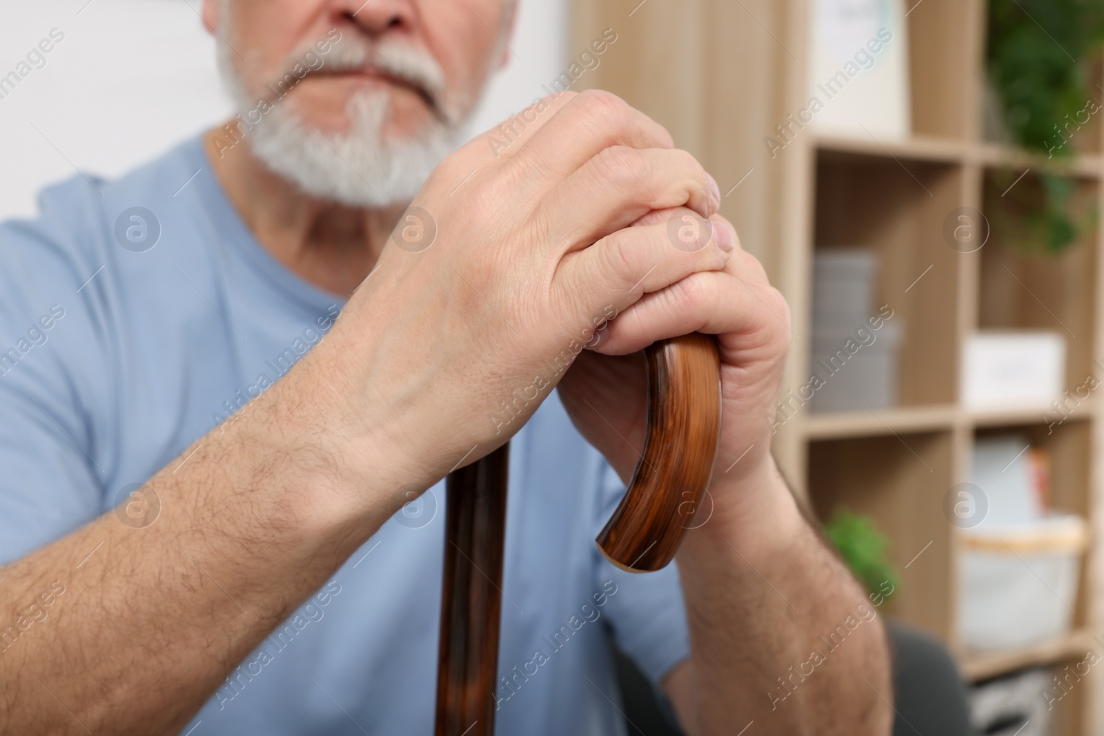 Photo of Senior man with walking cane at home, closeup