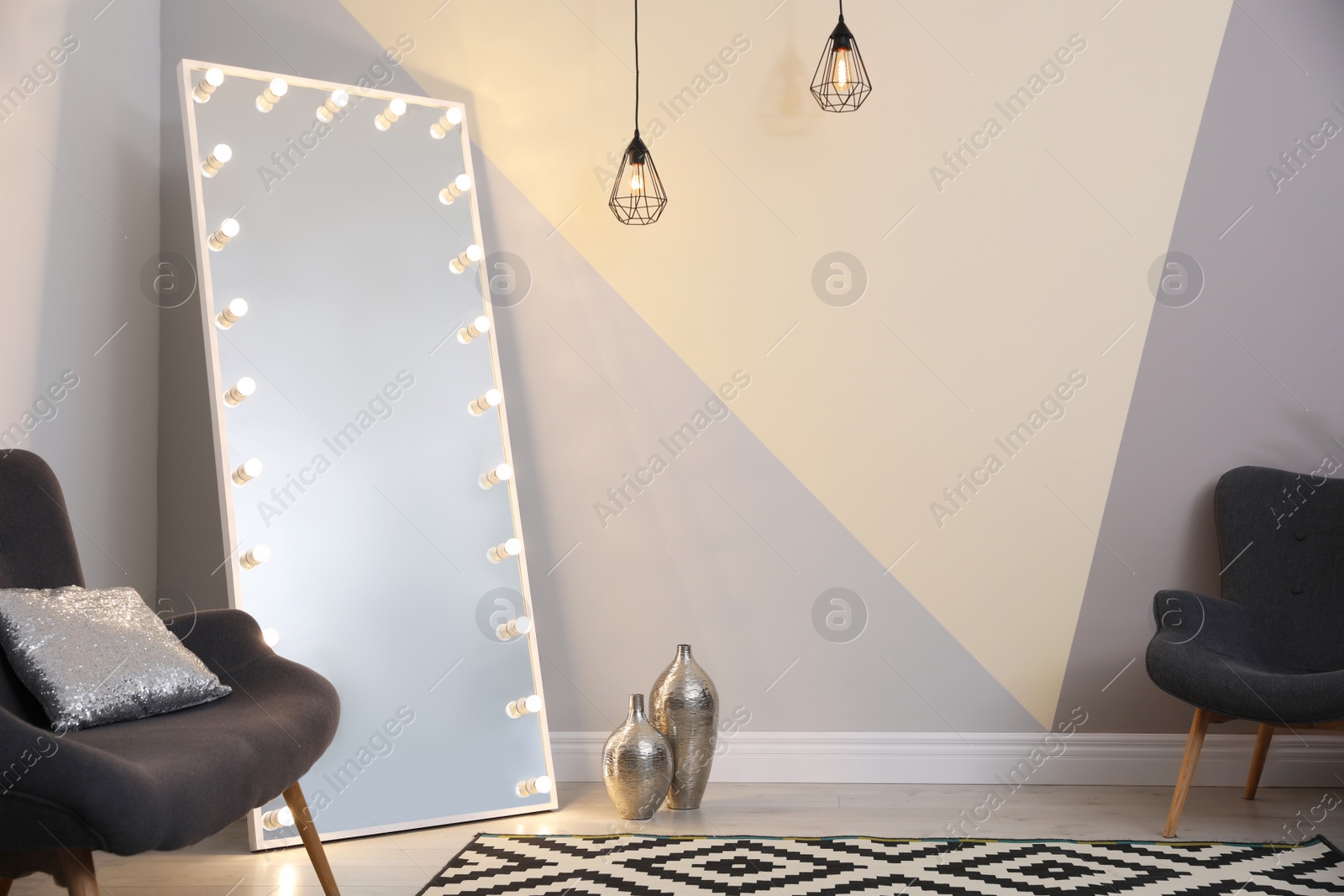 Photo of Large mirror with lamps in stylish room interior