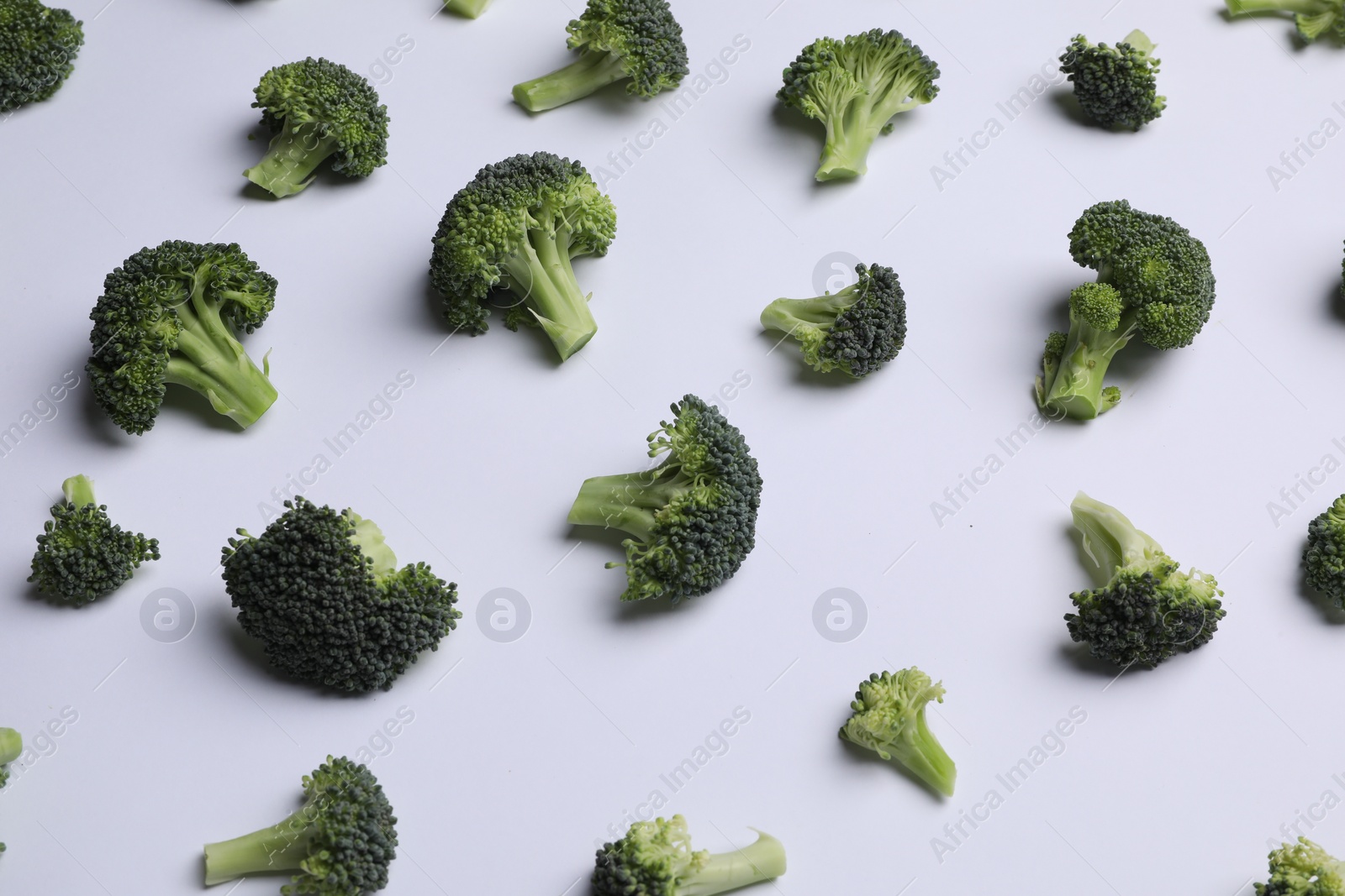 Photo of Many fresh green broccoli pieces on white background