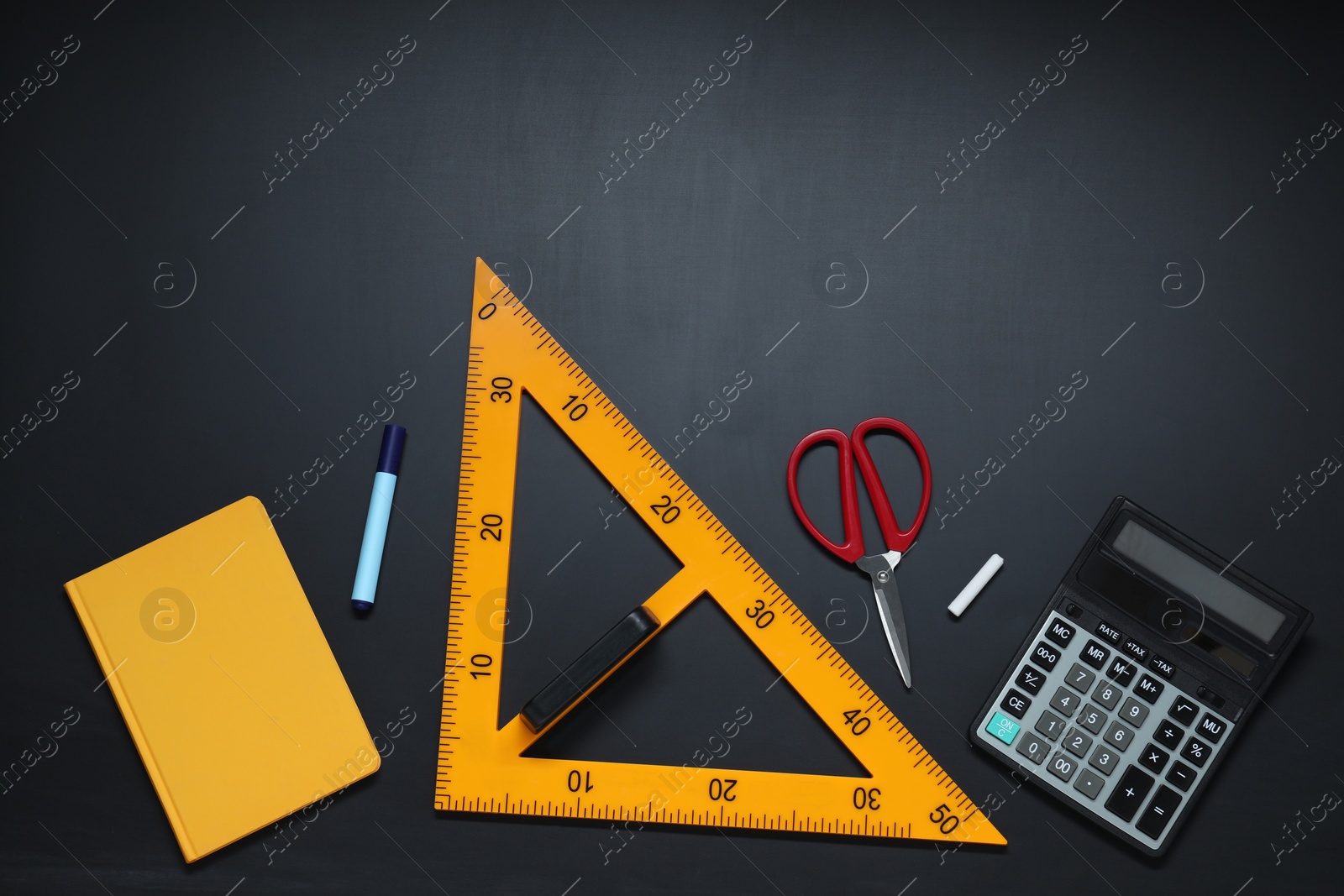 Photo of Triangle ruler, scissors, chalk, calculator, marker and notebook on black table, flat lay