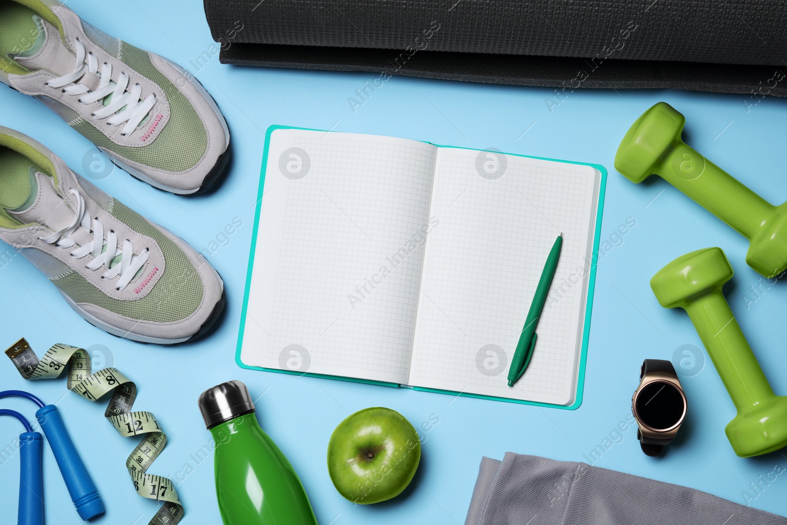 Photo of Notebook, pen and sports equipment on light blue background, flat lay. Personal training