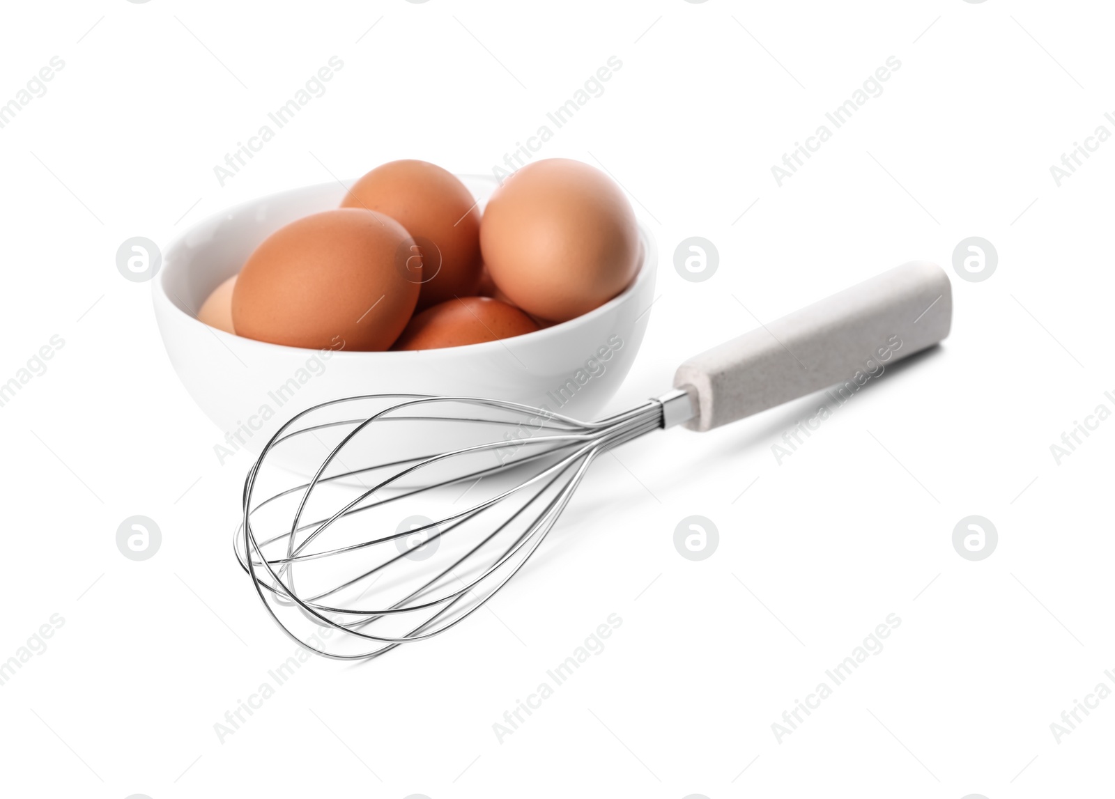 Photo of Whisk and bowl with raw eggs isolated on white