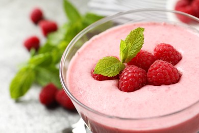 Delicious raspberry mousse with mint in glass dish, closeup