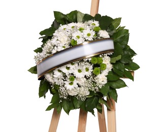Photo of Funeral wreath of flowers with ribbon on wooden stand against white background