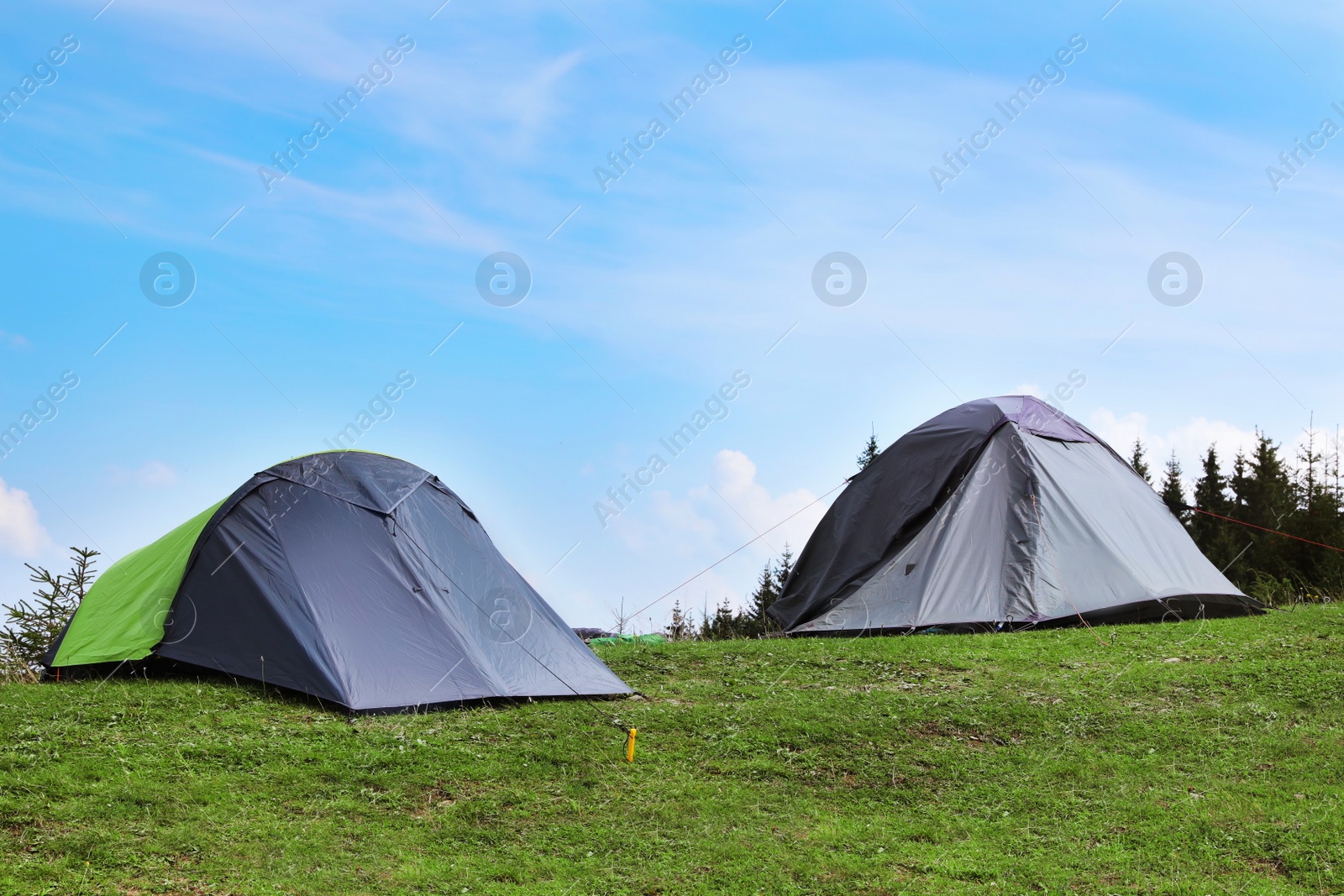 Photo of Small camping tents in mountains on sunny day