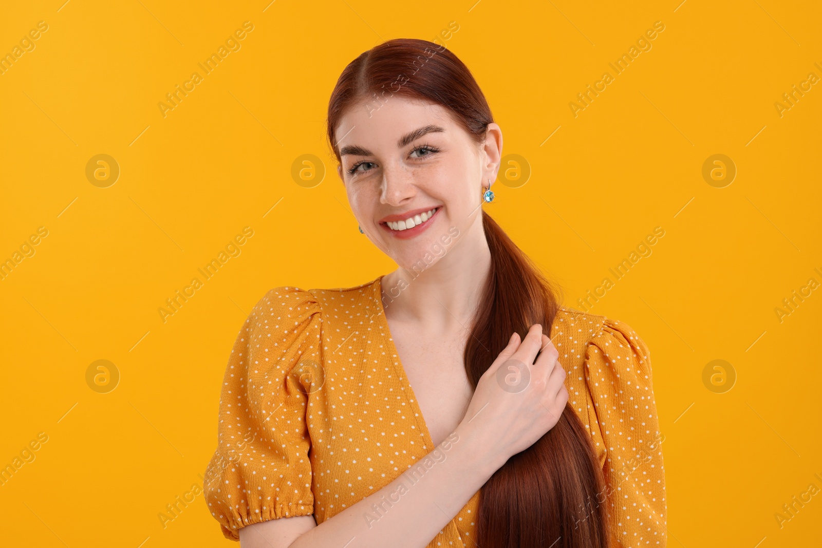 Photo of Portrait of smiling woman on yellow background