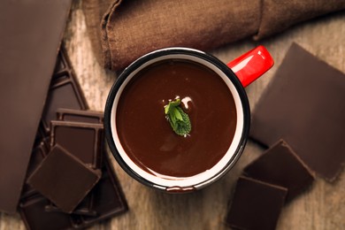 Photo of Mug of delicious hot chocolate with fresh mint leaves on wooden table, flat lay