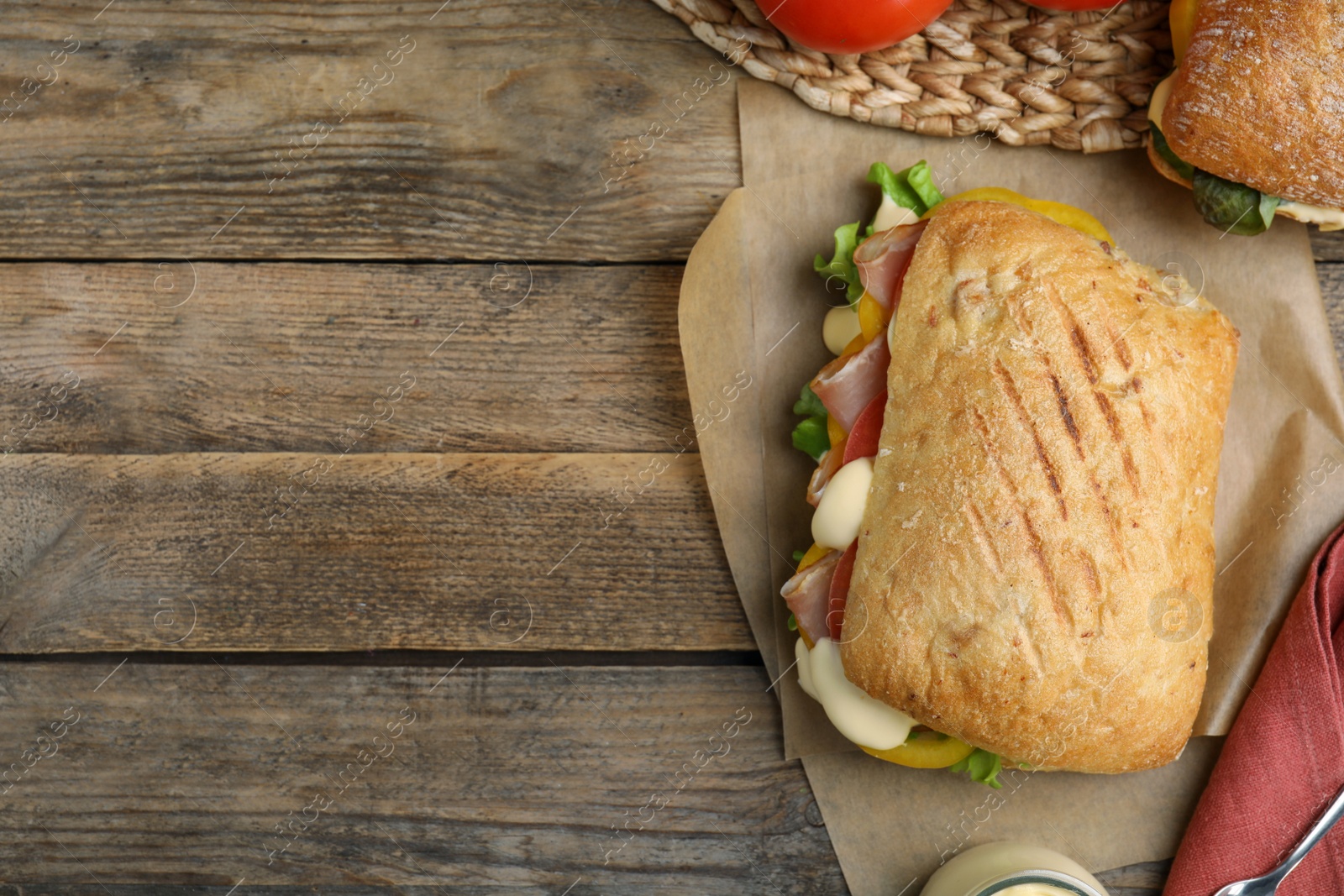 Photo of Delicious sandwich with vegetables, ham and mayonnaise served on wooden table, flat lay. Space for text