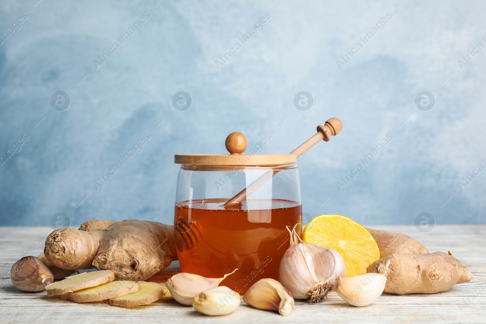 Photo of Fresh garlic and other natural cold remedies on white wooden table