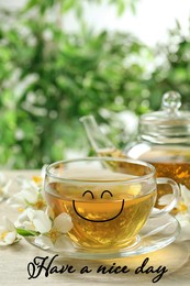 Text Have a nice day, glass cup of aromatic jasmine tea and fresh flowers on wooden table