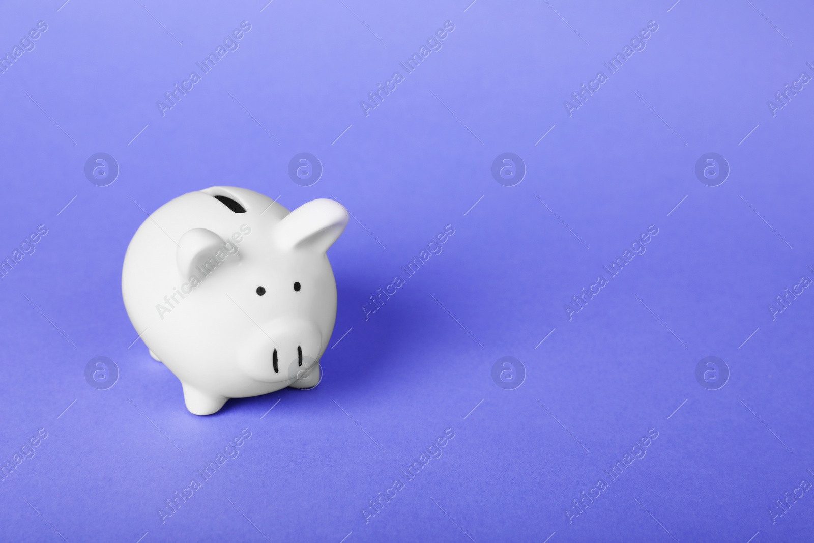 Photo of Ceramic piggy bank on purple background, space for text. Financial savings