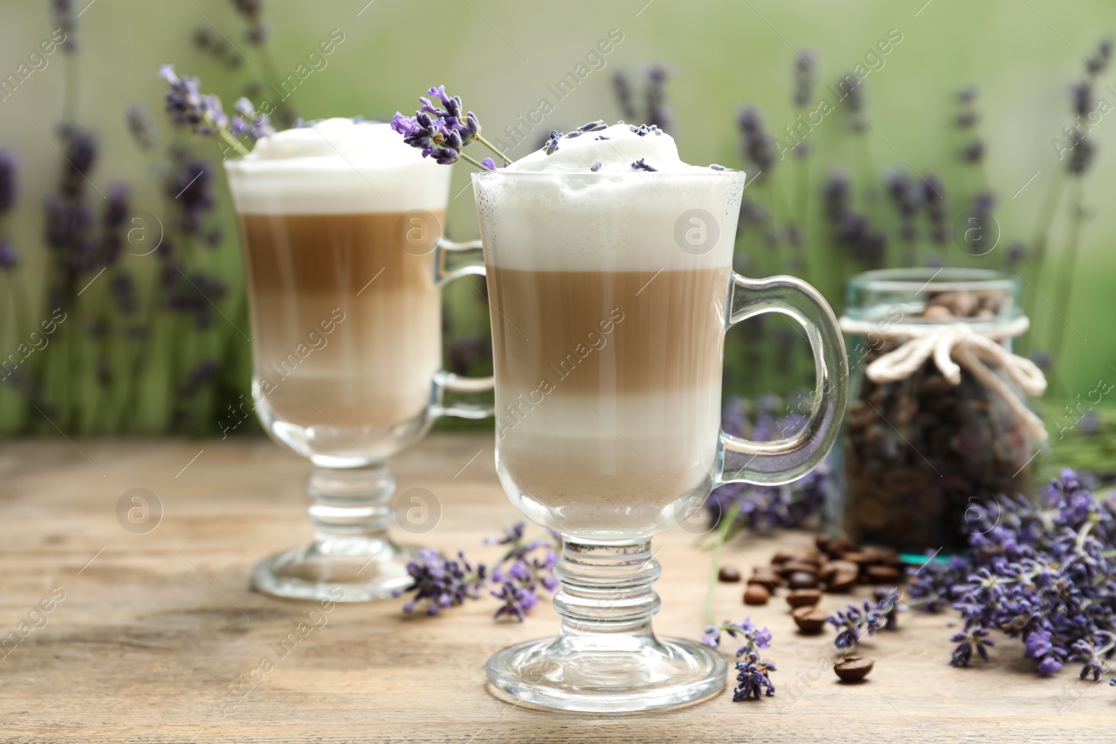 Photo of Delicious latte with lavender and coffee beans on wooden table